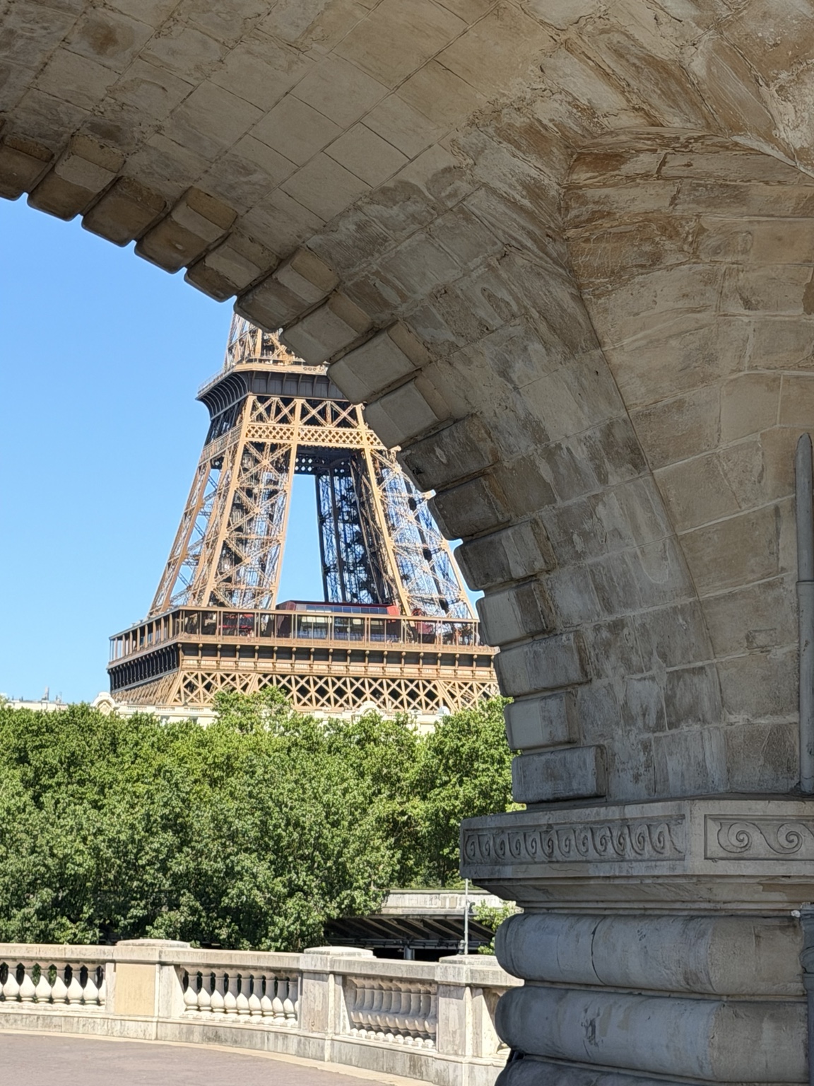 Torre Eiffel enmarcada por un arco de piedra