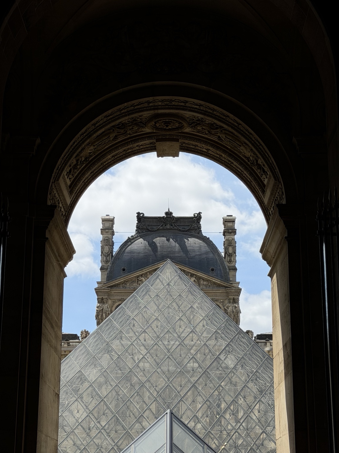 Pirámide del Louvre enmarcada por un arco
